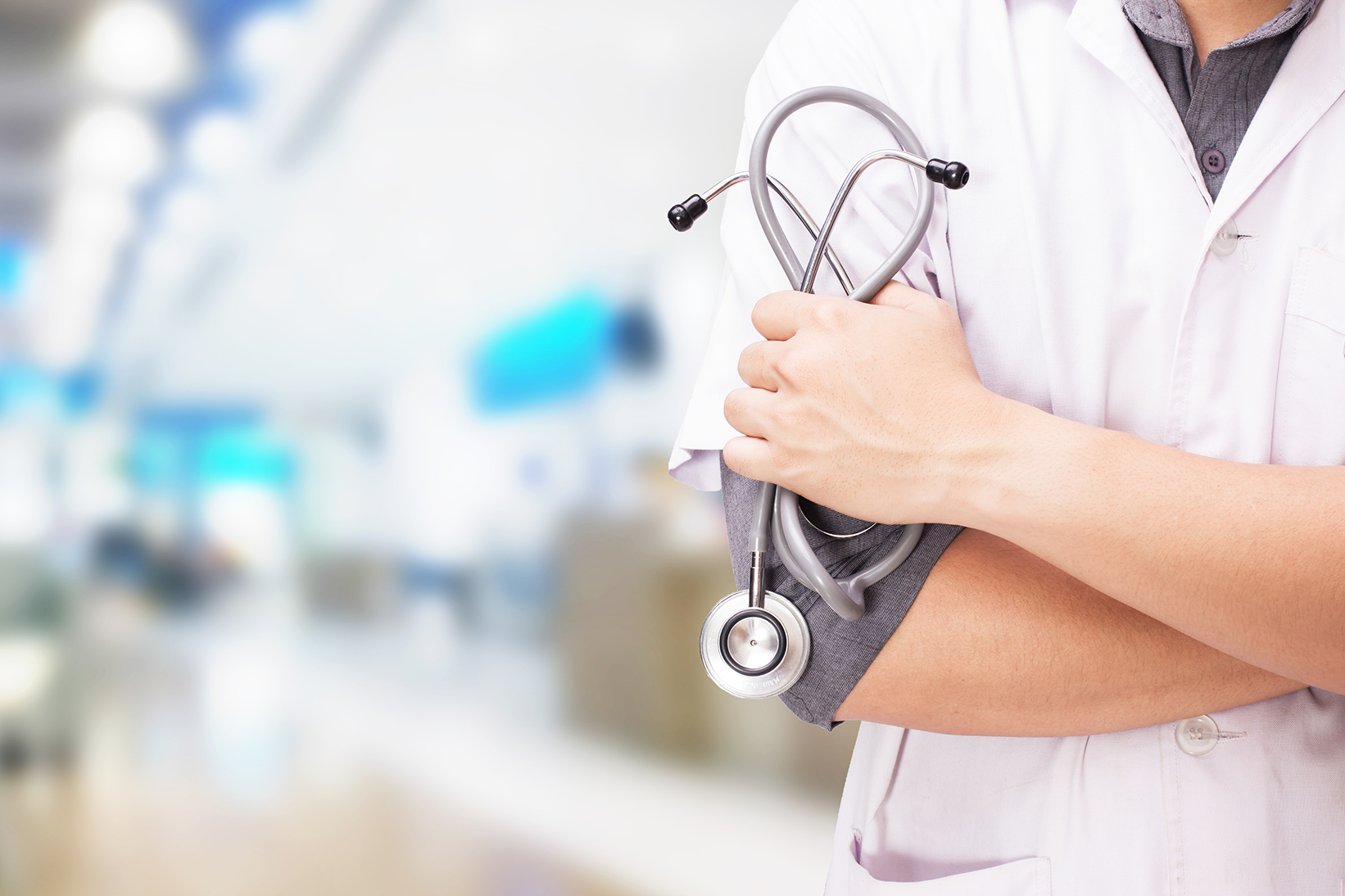 Doctor with a stethoscope in the hands and hospital background.